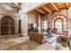 Spacious living room showcasing wood beams, stone columns, and a large tile floor at 20660 N 40Th St # 1112, Phoenix, AZ 85050