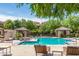 Community swimming pool surrounded by lush landscaping, cabanas, and lounge chairs at 20660 N 40Th St # 1112, Phoenix, AZ 85050