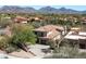 Aerial view of a beautiful home with a terracotta roof, surrounded by lush landscaping and mountain views at 21235 N 80Th Way, Scottsdale, AZ 85255