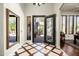 Elegant foyer featuring custom tile flooring, decorative iron door, and a view to the outdoor courtyard at 21235 N 80Th Way, Scottsdale, AZ 85255