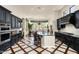 Stylish kitchen featuring black cabinets, an island with seating, and a seamless flow to the dining area at 21235 N 80Th Way, Scottsdale, AZ 85255