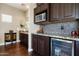 Minibar area with dark wood cabinets, granite countertop, and stainless steel appliances at 21235 N 80Th Way, Scottsdale, AZ 85255