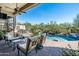 A covered patio overlooks a pristine pool and landscaped backyard at 21235 N 80Th Way, Scottsdale, AZ 85255