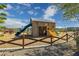Community playground with slides, tractor, wood fencing, and shaded structures for outdoor recreation at 22656 E Marsh Rd, Queen Creek, AZ 85142