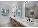 Elegant bathroom features double vanity, framed mirrors, modern fixtures, and large window for natural light at 2522 N Robin Ln, Mesa, AZ 85213