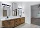 Modern bathroom with double sinks, wooden cabinets, and stylishly lit mirrors at 2522 N Robin Ln, Mesa, AZ 85213