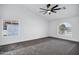 Bright bedroom features neutral carpet, a ceiling fan, and a picturesque arched window at 2522 N Robin Ln, Mesa, AZ 85213