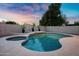 Backyard pool with a connected jacuzzi and desert landscaping under a colorful sunset at 2522 N Robin Ln, Mesa, AZ 85213