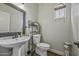 Bright bathroom with pedestal sink, decorative mirror, and tiled flooring at 2673 E Remington Pl, Chandler, AZ 85286