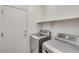 Well-lit laundry room with modern washer and dryer units, and ample shelving for storage at 2857 N Mystic Ct, Casa Grande, AZ 85122