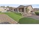 Backyard featuring artificial turf, desert landscaping, and a covered patio at 2894 E Nolan Pl, Chandler, AZ 85249