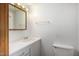Bathroom featuring white cabinet and sink, overhead light, and toilet adjacent to wall at 300 S Val Vista Dr # 167, Mesa, AZ 85204