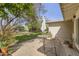 View of the backyard with mature trees, green lawn, and an outdoor seating area with an umbrella at 302 E Orange Dr, Phoenix, AZ 85012
