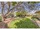 An inviting backyard with mature trees, lush green grass, and brick paver borders at 302 E Orange Dr, Phoenix, AZ 85012