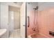This bathroom features a shower/tub combo with pink tiles, a handrail, and a door to the closet at 302 E Orange Dr, Phoenix, AZ 85012