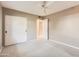 This bedroom features neutral walls, carpet floors, a ceiling fan, and closet with white doors at 302 E Orange Dr, Phoenix, AZ 85012
