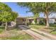 Charming single-story home featuring a well-maintained lawn and a brick-accented driveway leading to a covered carport at 302 E Orange Dr, Phoenix, AZ 85012
