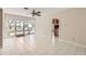 This living room features white tiled floors, a ceiling fan, and glass sliding doors to the backyard at 302 E Orange Dr, Phoenix, AZ 85012