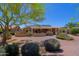 View of the backyard with desert landscaping, covered patio, and solar panels at 3147 N Couples Dr, Goodyear, AZ 85395