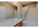 Bathroom features a wood vanity, framed mirror, tub, shower and neutral color palette at 3147 N Couples Dr, Goodyear, AZ 85395