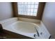 Modern bathroom featuring a soaking tub with glass block window for natural light at 3147 N Couples Dr, Goodyear, AZ 85395