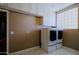 Bright laundry room featuring a new washer and dryer, tile floor, and custom cabinets at 3147 N Couples Dr, Goodyear, AZ 85395