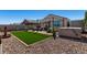 This landscaped backyard features pavers, synthetic grass, a spa, and desert rock at 3670 E Sandoval Dr, San Tan Valley, AZ 85140