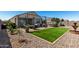This backyard has an outdoor living area, a manicured lawn, and rock landscaping at 3670 E Sandoval Dr, San Tan Valley, AZ 85140