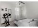 Comfortable bedroom with a cozy bed, neutral tones, complemented by an exercise bike, and plenty of natural light at 3670 E Sandoval Dr, San Tan Valley, AZ 85140