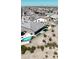 Aerial view showcases a backyard pool, patio with artificial turf, and desert landscaping; complemented by neighborhood views at 3907 S 75Th Dr, Phoenix, AZ 85043