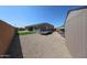 Fully fenced backyard with gravel, lawn, home and a storage shed at 3907 S 75Th Dr, Phoenix, AZ 85043