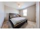 Bedroom with a dark wood bed frame, neutral walls, and a bright window for ample natural light at 3907 S 75Th Dr, Phoenix, AZ 85043