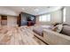 Open-concept living room features a comfy couch, a large window, a TV, and wood flooring at 3907 S 75Th Dr, Phoenix, AZ 85043