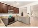 Kitchen with stainless steel appliances, granite countertops, dark cabinets and tile floor at 43142 N Outer Bank Dr, Anthem, AZ 85086