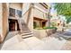 A two-story home with tan stucco walls and a stairway leading up to the front door, surrounded by landscaping at 4554 E Paradise Village Pkwy # 161, Phoenix, AZ 85032