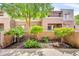 A well-maintained two-story home with tan stucco walls and lush landscaping in front at 4554 E Paradise Village Pkwy # 161, Phoenix, AZ 85032