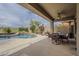 A backyard pool with a waterfall feature, patio area and seating at 4864 E Eden Dr, Cave Creek, AZ 85331