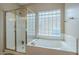 Modern bathroom with a glass shower, soaking tub, and glass block window at 4864 E Eden Dr, Cave Creek, AZ 85331