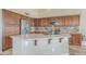 Kitchen island with a sink, custom cabinets, stainless steel appliances, and breakfast bar at 4864 E Eden Dr, Cave Creek, AZ 85331