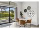 Cozy dining area with access to the backyard and modern clocks on the wall at 5036 N Scottsdale Rd, Paradise Valley, AZ 85253