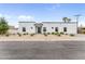 A modern, white home with dark window trim is surrounded by desert landscaping and a well-maintained yard at 5036 N Scottsdale Rd, Paradise Valley, AZ 85253