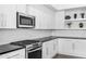 Modern kitchen featuring white cabinets, stainless steel appliances, and geometric backsplash at 5036 N Scottsdale Rd, Paradise Valley, AZ 85253