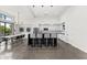 Modern kitchen with black island and bar seating overlooks dining area with seating for six at 5036 N Scottsdale Rd, Paradise Valley, AZ 85253