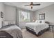 Well-lit bedroom featuring two beds, a ceiling fan, and a large window with bright natural light at 5401 E Van Buren St # 3113, Phoenix, AZ 85008