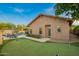 View of a green backyard featuring a putting green, patio, and pool at 5528 W Mine Trl, Phoenix, AZ 85083