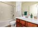 Bright bathroom with a white shower-tub, single sink vanity, and tile flooring at 5528 W Mine Trl, Phoenix, AZ 85083