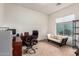 Cozy bedroom featuring a dark wood desk, comfortable sofa, and large window at 5528 W Mine Trl, Phoenix, AZ 85083