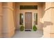 Charming front entrance with decorative plants, transom window and neutral tones at 5528 W Mine Trl, Phoenix, AZ 85083