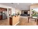 Bright, open kitchen with stainless steel appliances and island seating, flows into the spacious living area at 5528 W Mine Trl, Phoenix, AZ 85083