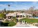 Expansive property showcases well-manicured lawns, a pool, and a charming outdoor lounge area at 7635 E Sweetwater Ave, Scottsdale, AZ 85260